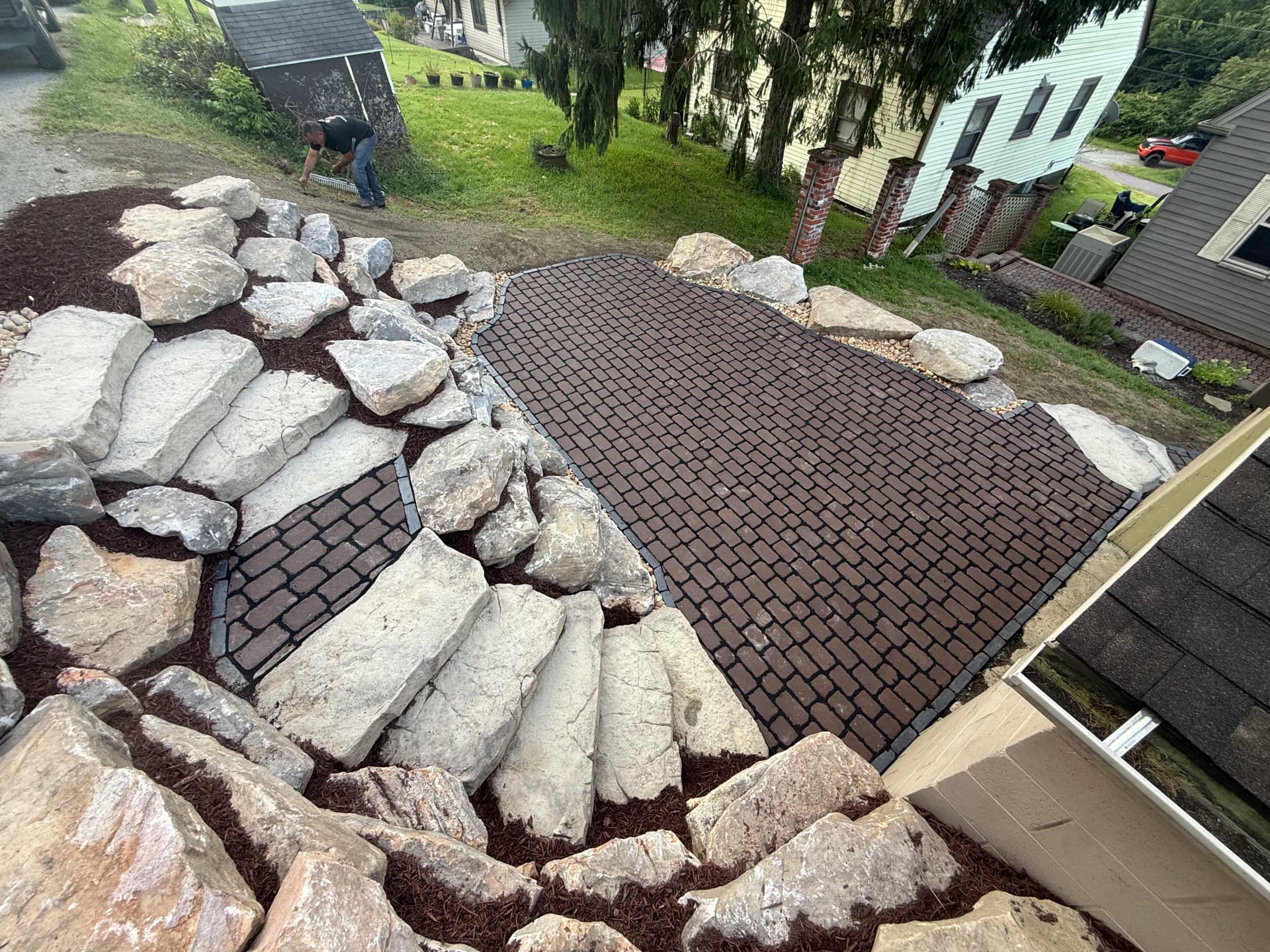 Steep Driveway Slope Gets a Boulder Wall and Paver Patio Upgrade image